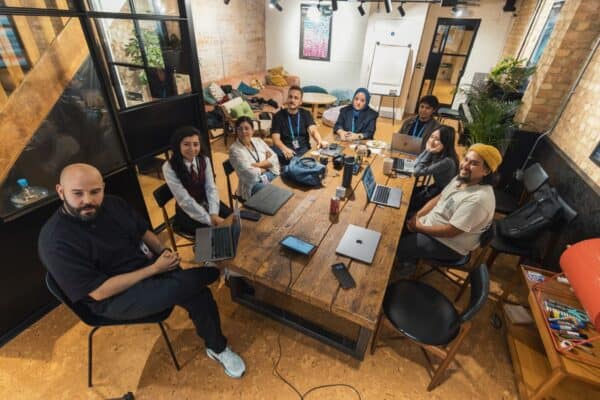 Diverse business team collaborating on laptops in a modern office reviewing web design work